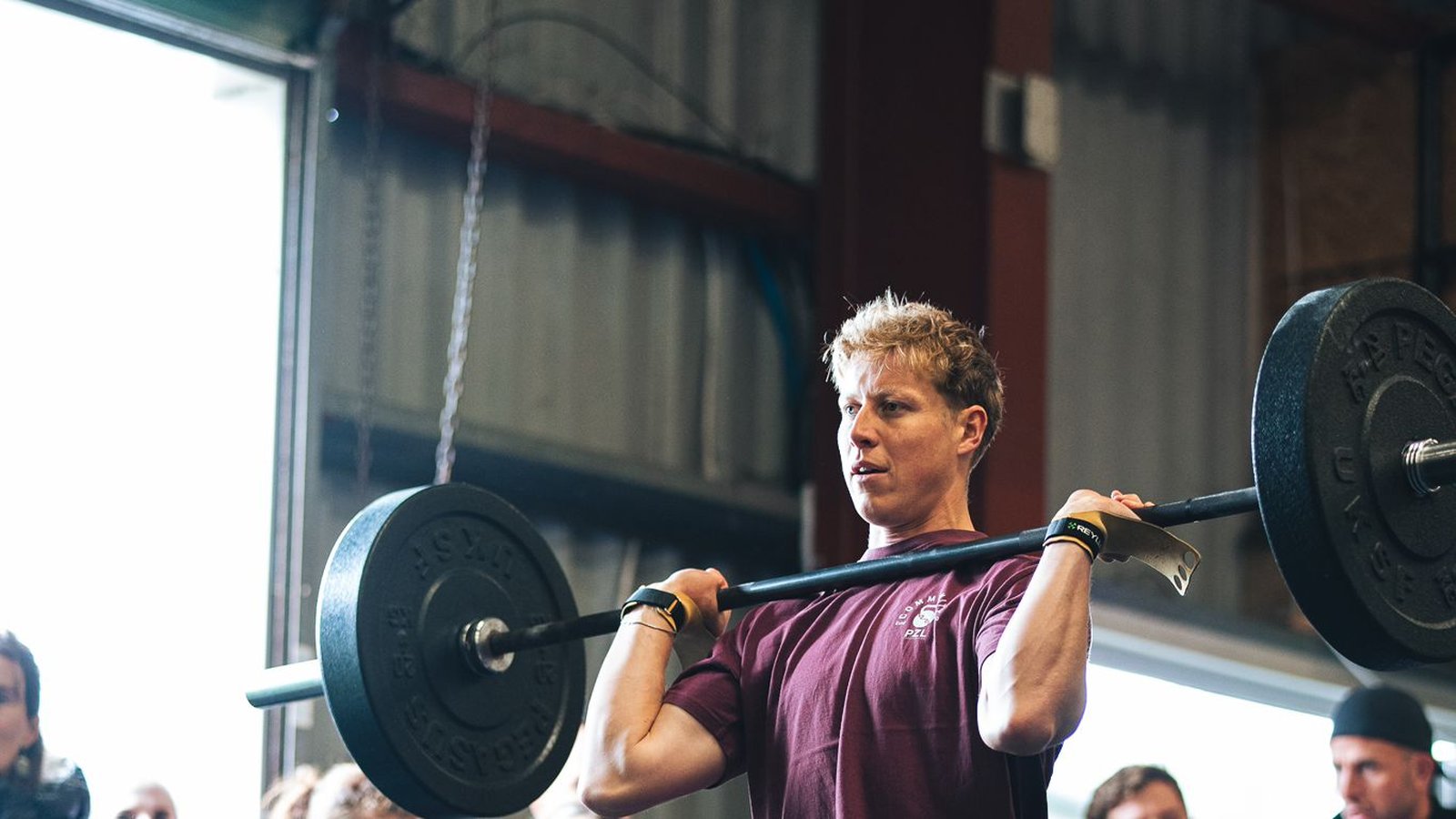 Athlete performing a barbell overhead lift at a competition